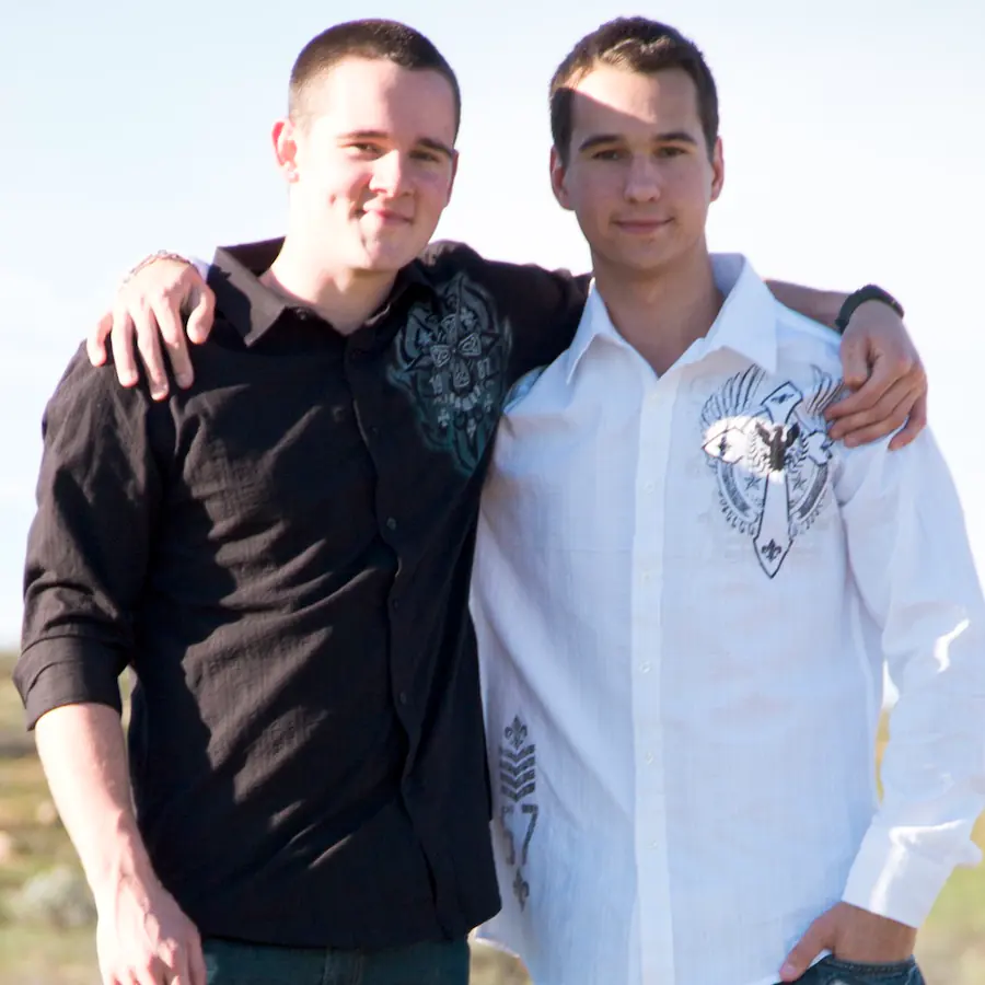 Brothers Nolan and Roman standing side by side with their arms around each other, smiling at the camera
